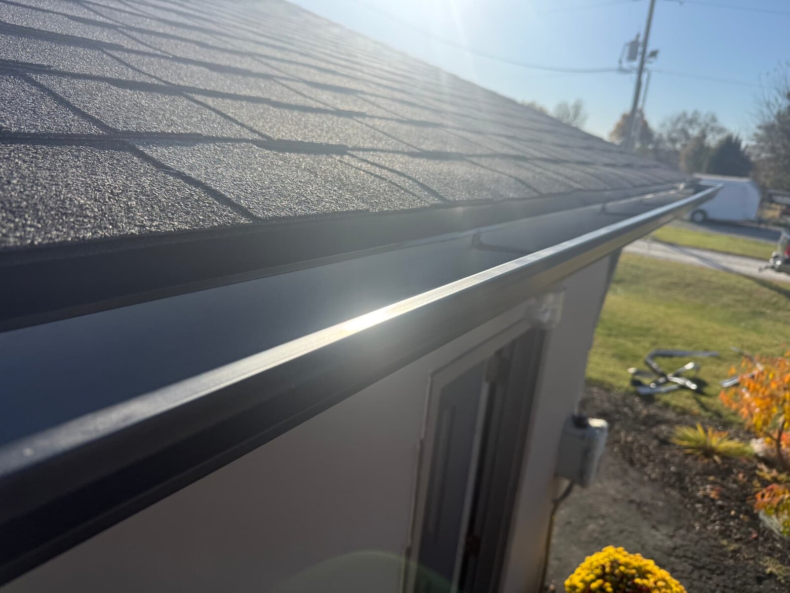New black seamless gutter installed on a residential roof