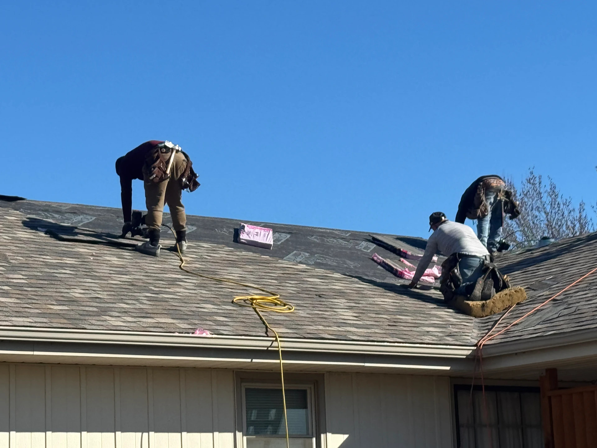 EZ Restoration crew installing new shingles on a residential roof