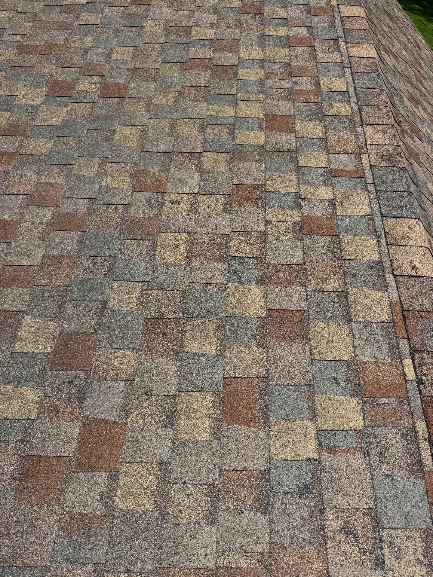 Sun-faded shingle field with widespread granule wear before replacement
